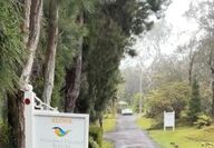 Sign for hotel with long driveway leading to bungalows.